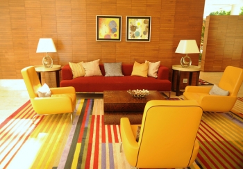 Lounge room, sofas, pillows, armchairs, end tables, lamps, art, wood walls, striped carpet, red and yellow, contemporary furniture, Renaisance Hotel, Schaumburg, Illinois, USA